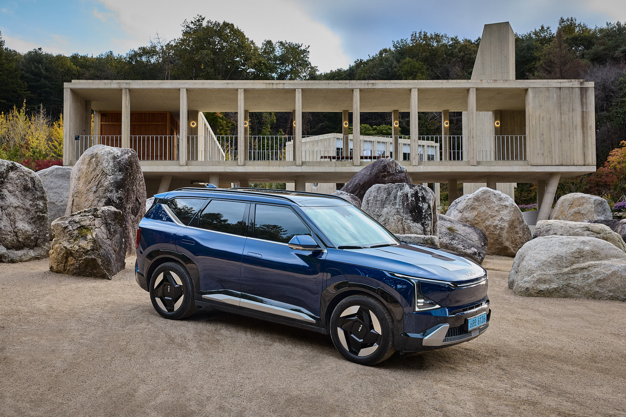 Kia EV5 among stone landscape and Médongaule concrete architecture