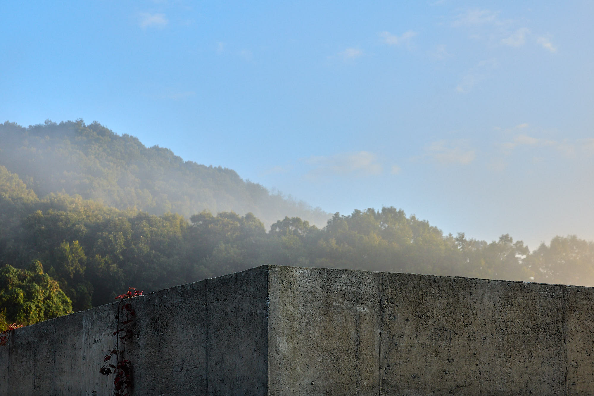 Myök concrete architecture against misty mountains at sunrise