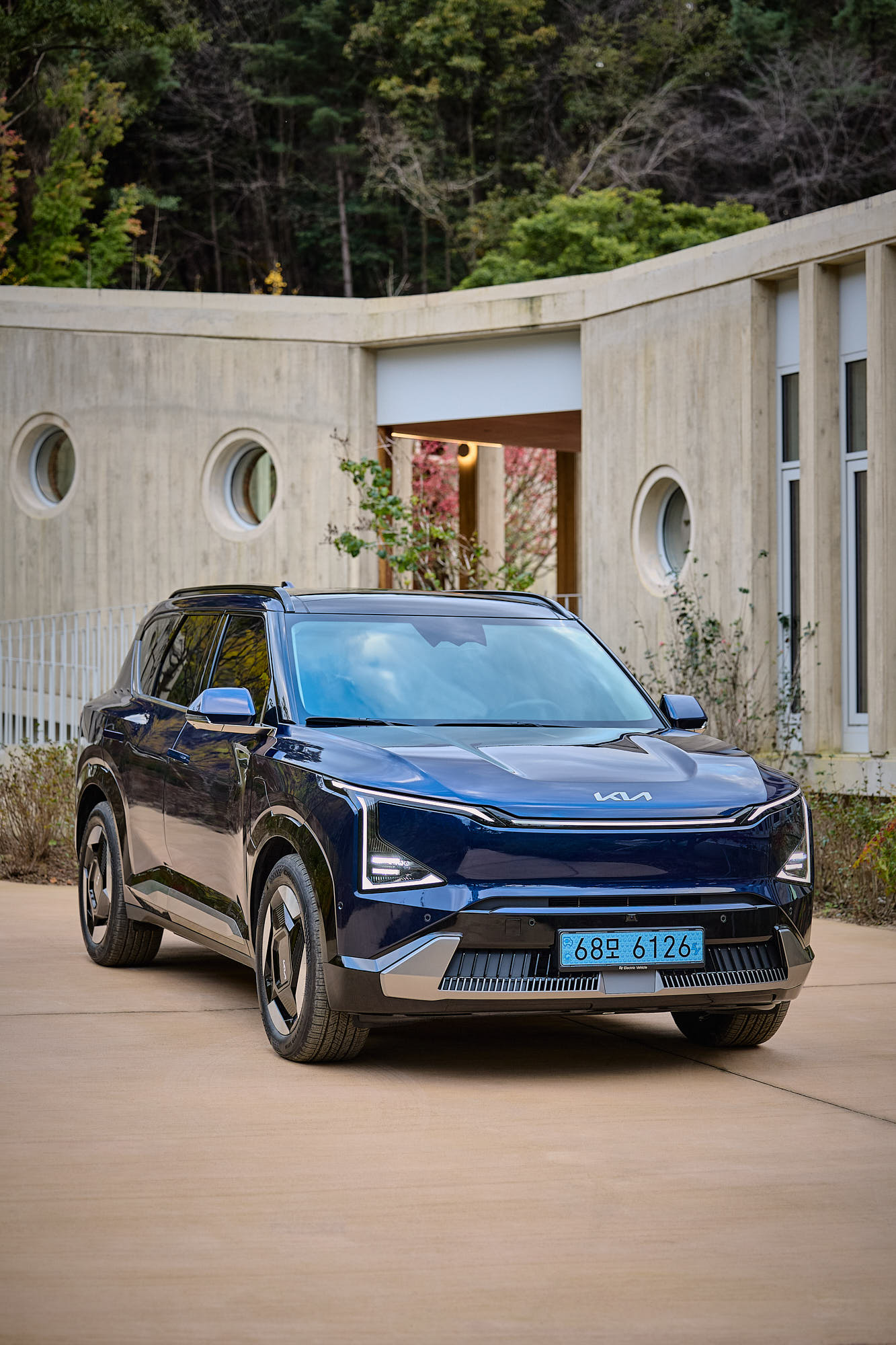 Kia EV5 framed by Médongaule concrete architecture and circular windows