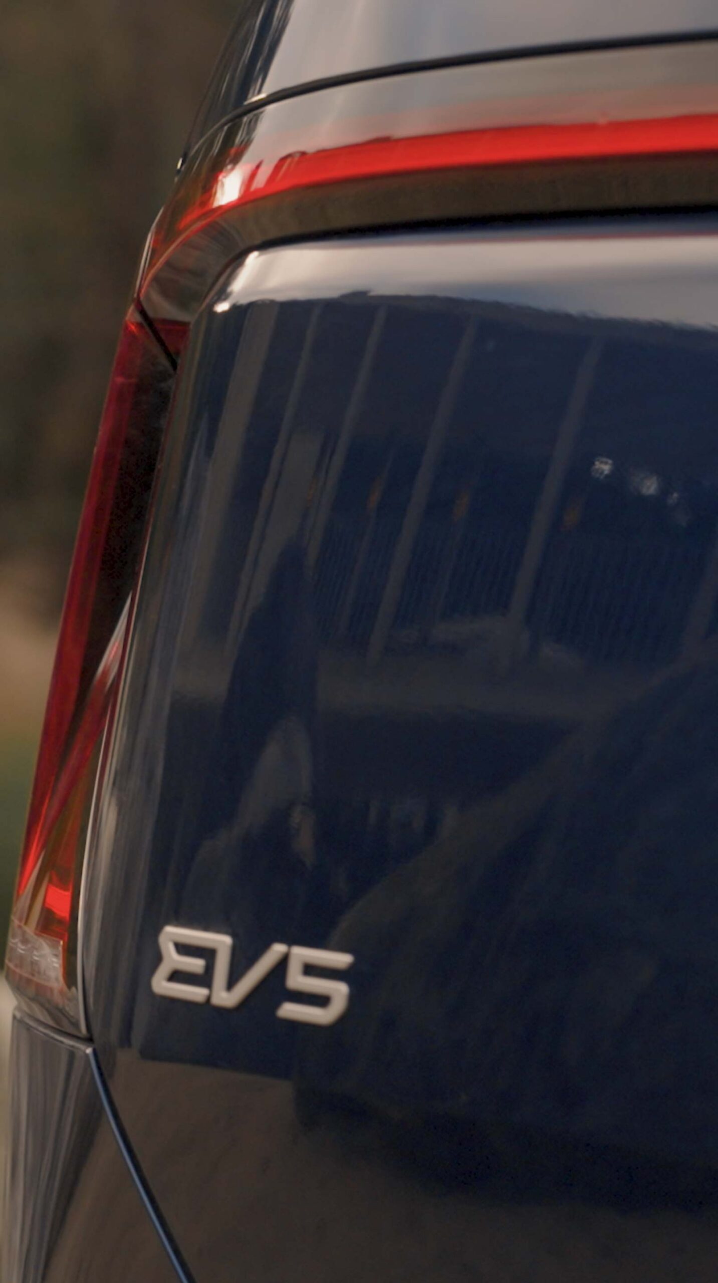 Close-up of Kia EV5 rear design and taillight reflecting Médongaule