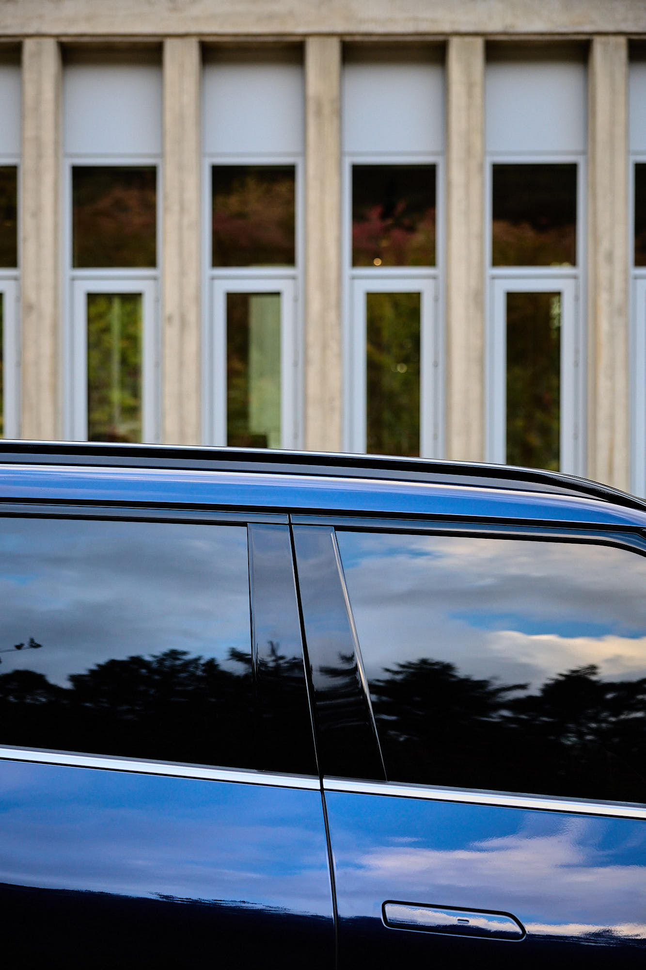 Kia EV5 side profile reflecting sky and trees at Médongaule
