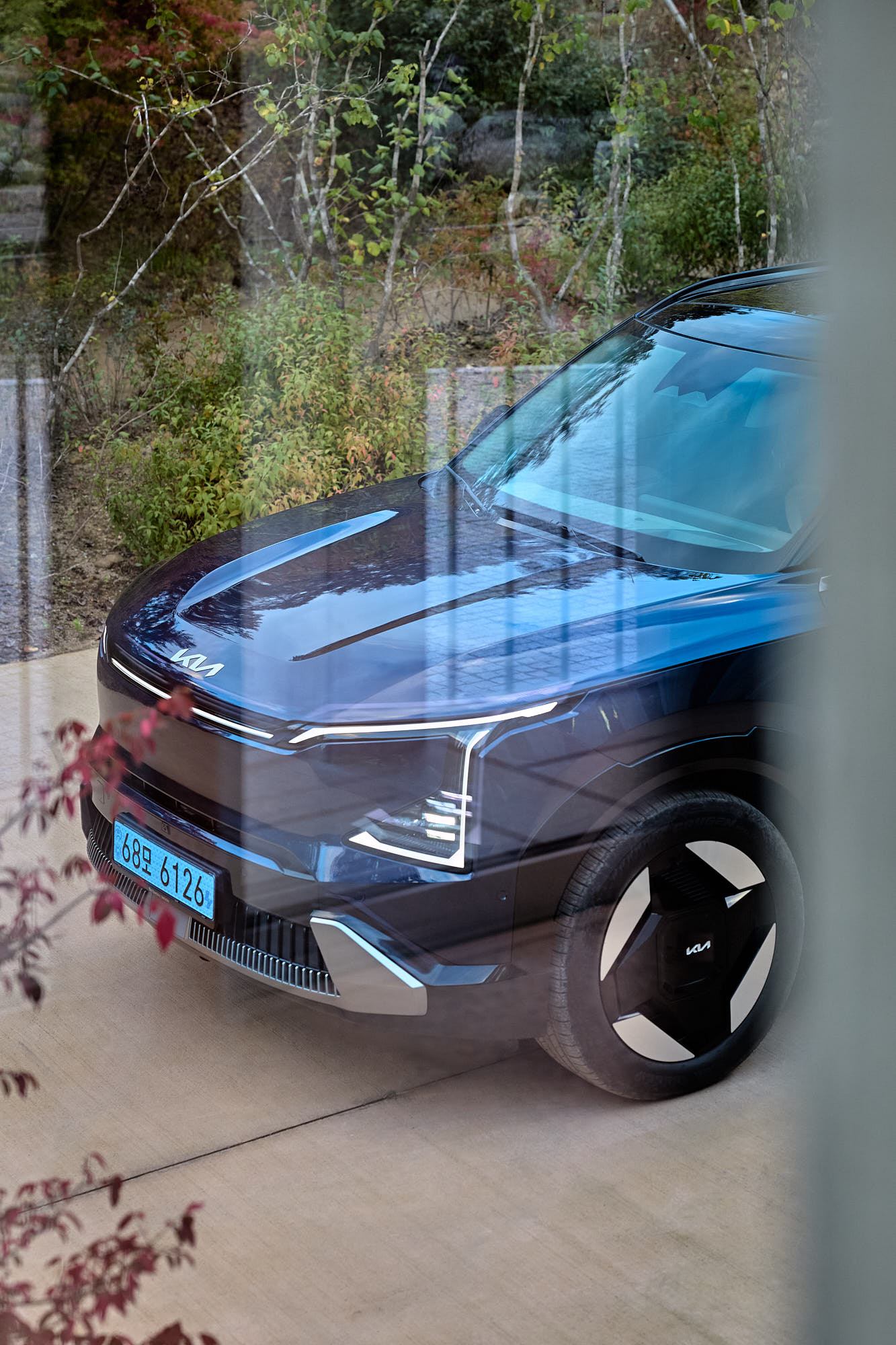 Kia EV5 front design seen through reflections at Médongaule