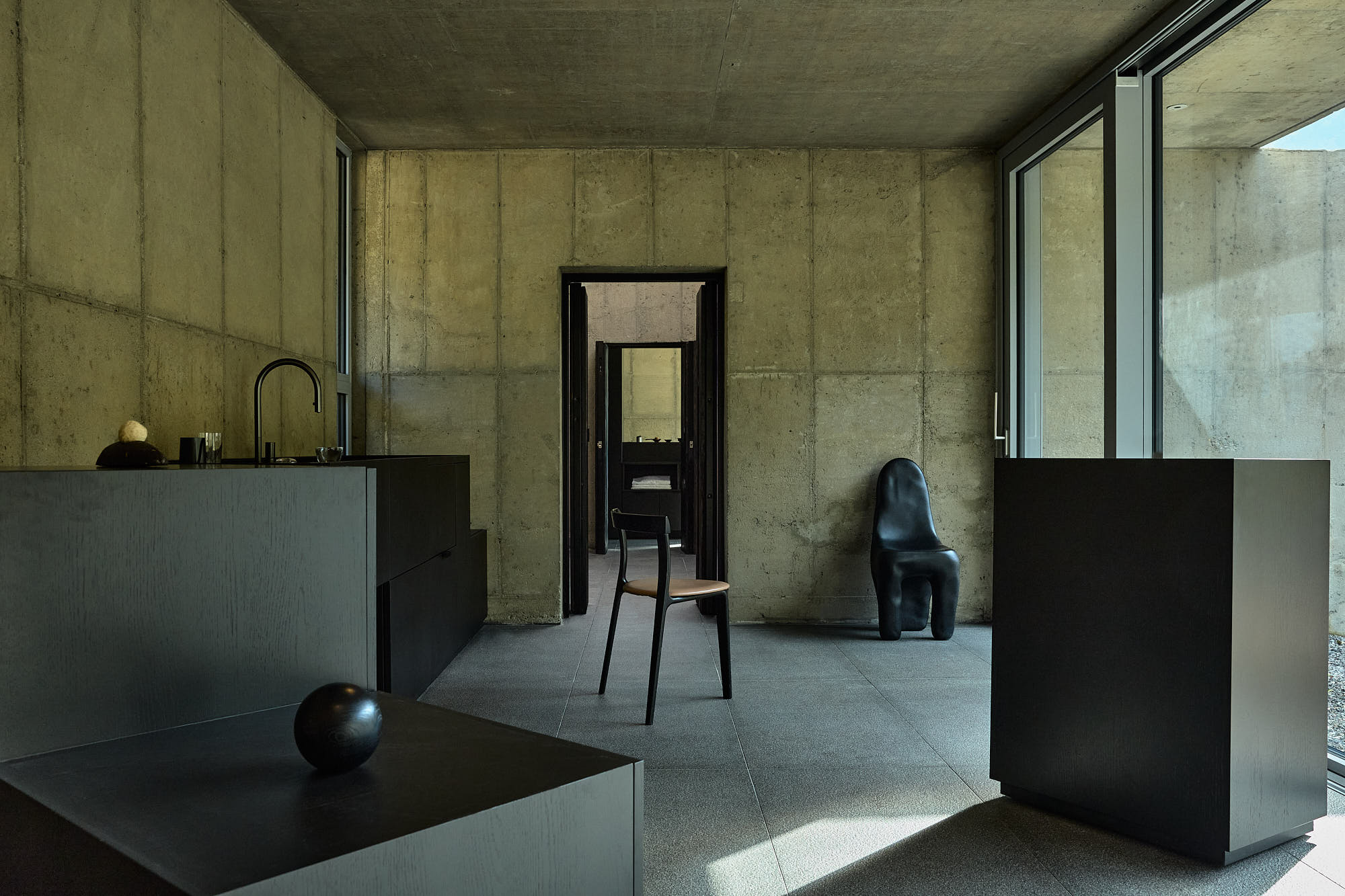 Minimal concrete interior with sculptural furniture at Myök