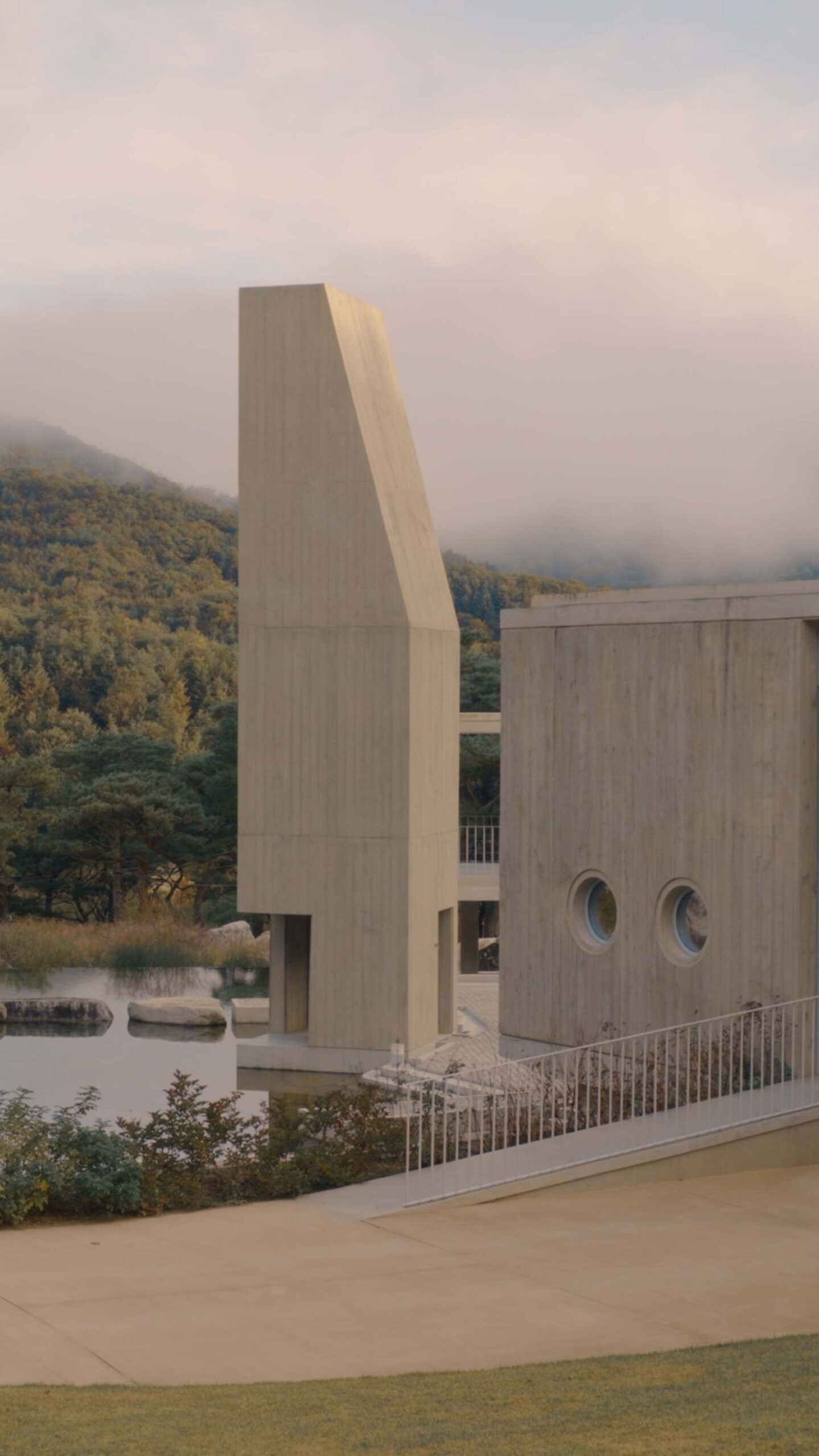 Médongaule concrete architecture and reflecting pool against misty mountains