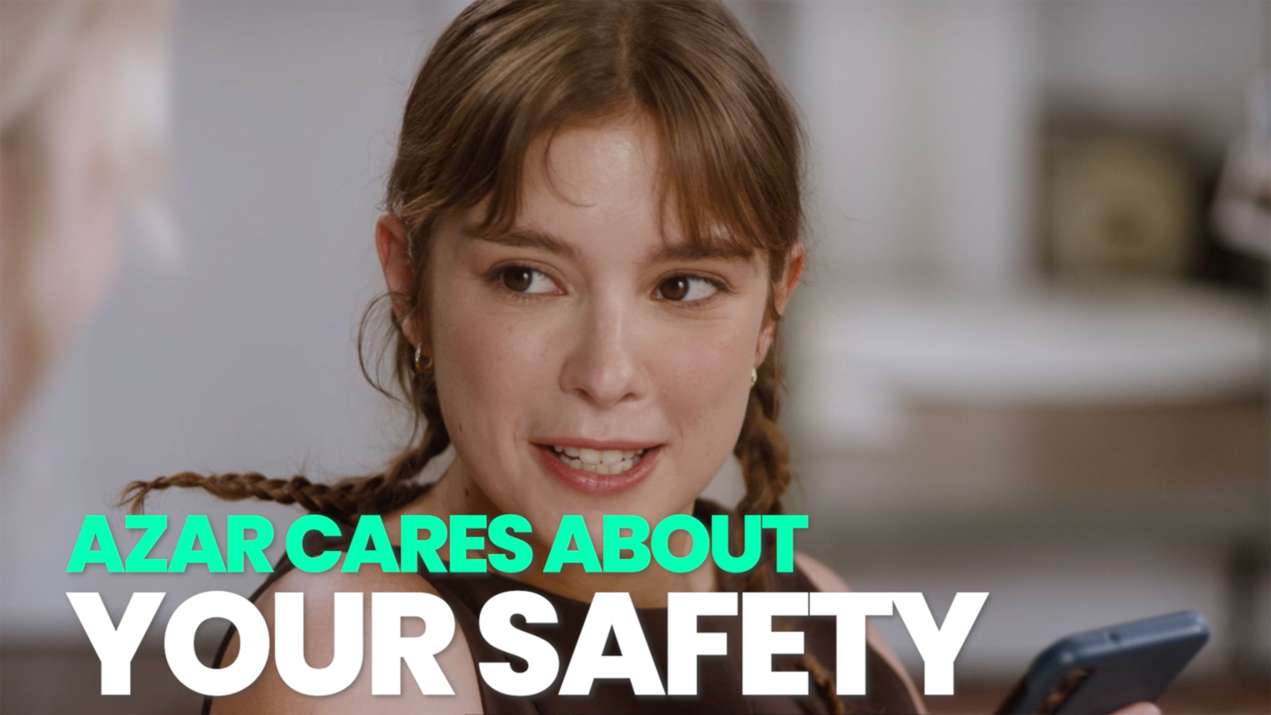 Myeong-i Han holding a phone with an Azar safety message