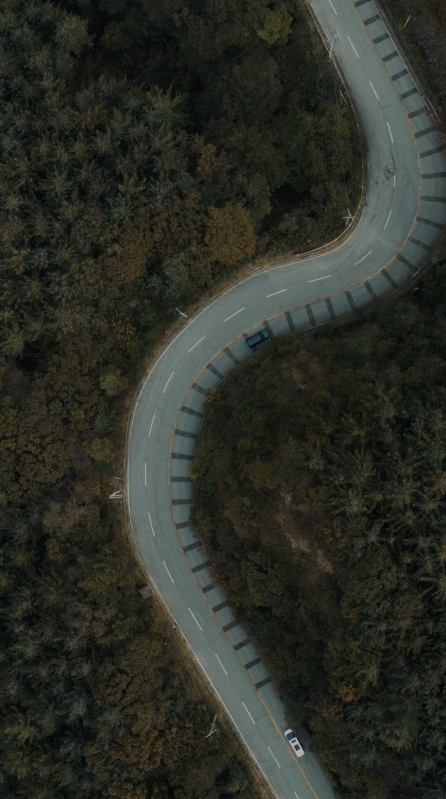 Aerial view of Kia EV5 driving on an autumn mountain road near Médongaule
