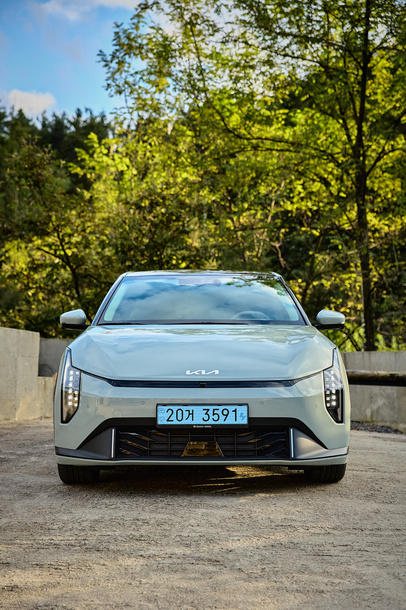 Front view of Kia EV4 surrounded by dense forest at Myök